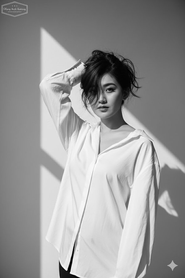 A portrait of a person wearing a loose white shirt.